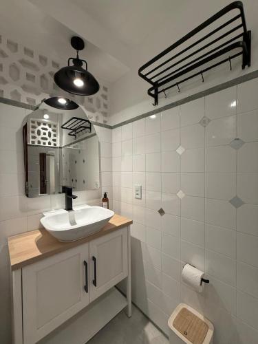 a white bathroom with a sink and a mirror at Estrela de Mundaú in Trairi