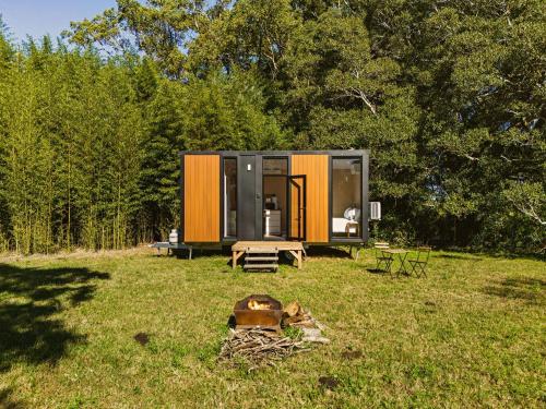 a small cabin in the middle of a field at Huntingdon House by Tiny Away in Wauchope