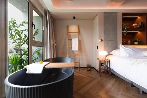 a bathroom with a tub next to a bed at BoH Collection in Medellín