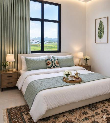 a bedroom with a large bed with a large window at Orchid Villa salalah in Salalah