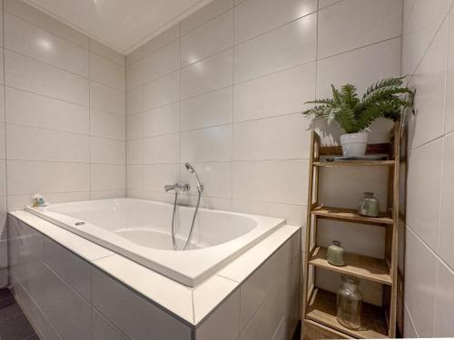 a bath tub with a faucet in a bathroom at Waddenhuis in Westerland