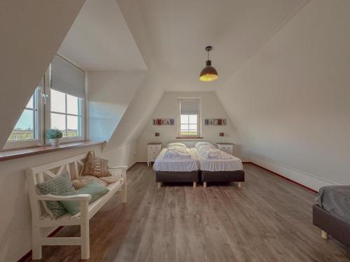 a attic bedroom with two beds and a chair at Waddenhuis in Westerland