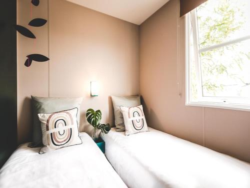 two beds in a room with a window at Wadden Lodge Plus in Westerland
