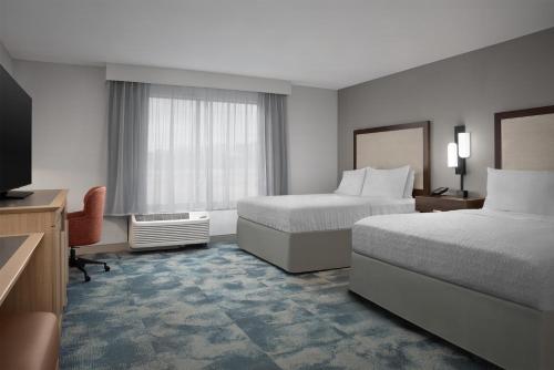 a hotel room with two beds and a television at Hampton Inn Yemassee/Point South, Sc in Yemassee