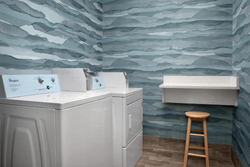 a washing machine and a stool in a laundry room at Hampton Inn Yemassee/Point South, Sc in Yemassee