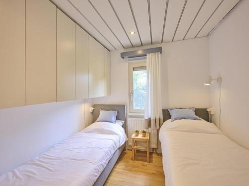 two beds in a room with a window at Huisje Joep in Goedereede