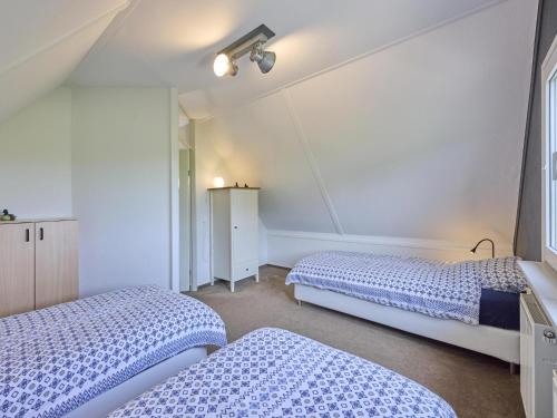 two beds in a room with blue and white at Poldergeluk in Ooltgensplaat