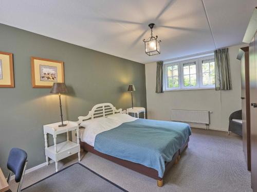 a bedroom with a bed and two tables and a window at Heidepracht in Putten