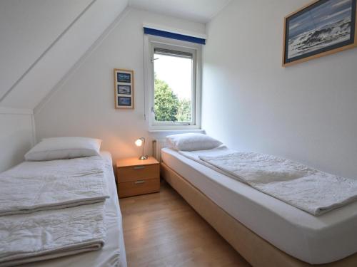 two beds in a room with a window at Graspieper in Zonnemaire