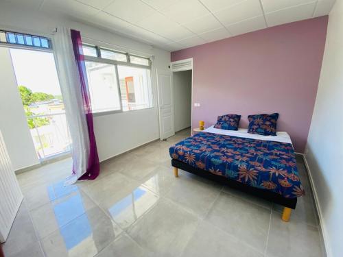 a bedroom with a bed and a large window at Grand appartement ventilé in Morne-à-lʼEau