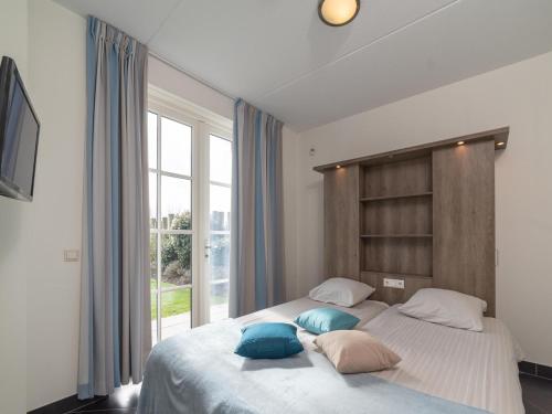 a bedroom with a large bed with pillows on it at Zwembadvilla in Colijnsplaat