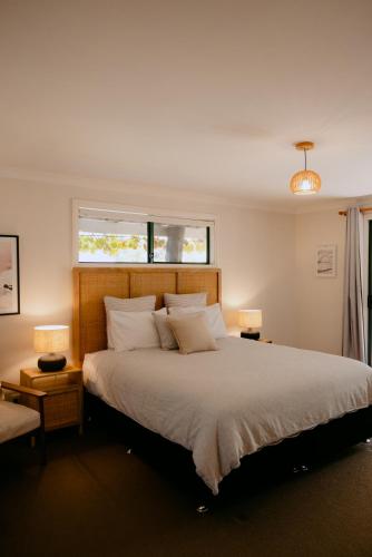 a bedroom with a large white bed with two lamps at Norfolk House in Dunsborough