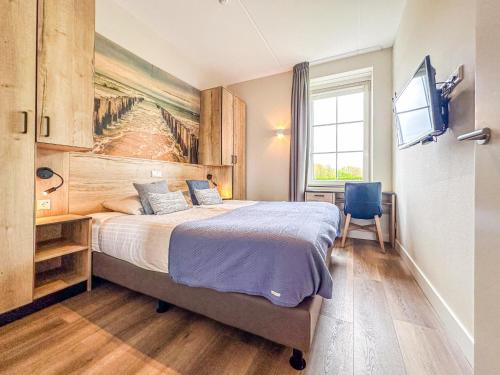 a bedroom with a large bed and a television at Garden de luxe 27B in Colijnsplaat
