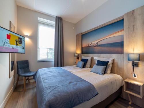 a hotel room with a bed and a flat screen tv at La Mer Luxe in Colijnsplaat