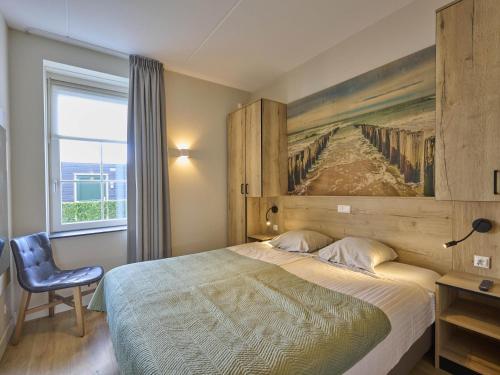 a bedroom with a bed with a painting on the wall at Sauna Zee 27A in Colijnsplaat