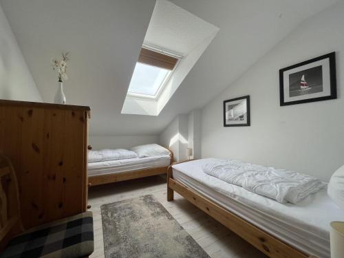 a bedroom with two beds and a window at Panoramablick-Orther-Hafen-Fehmarn in Orth