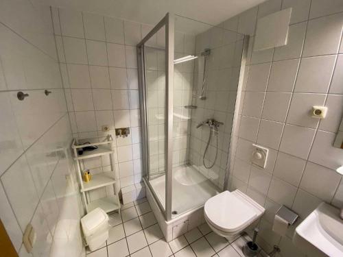 a white bathroom with a shower and a toilet at Panoramablick-Orther-Hafen-Fehmarn in Orth