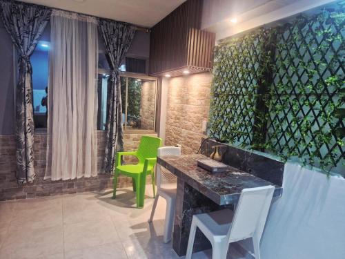 a room with a table and two green chairs at Hospedaje Saray Sofia in Coveñas