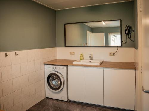 a bathroom with a washing machine and a sink at Alpacafarm Vorstenbosch in Vorstenbosch