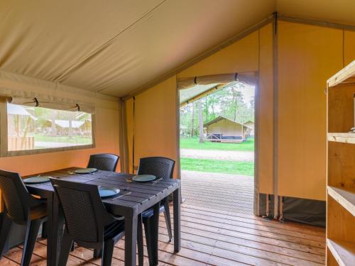 a dining room with a table and chairs in a tent at Safaritent 4 in Vessem