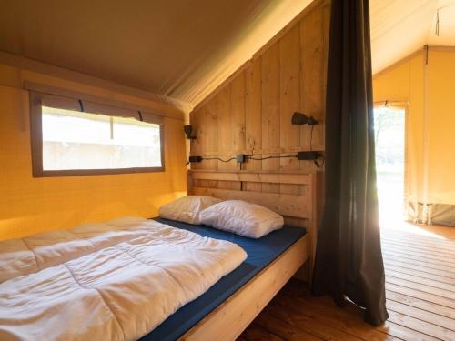 a large bed in a room with a window at Safaritent 4 in Vessem
