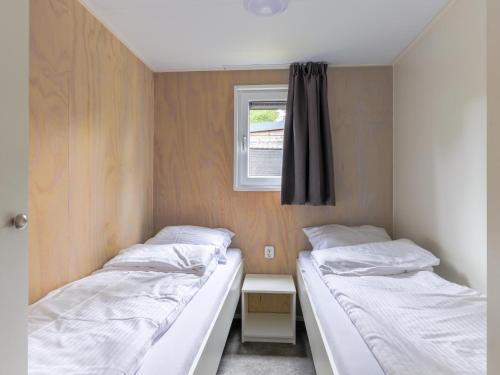 two beds in a small room with a window at Woodlodge XL 588 in Vessem