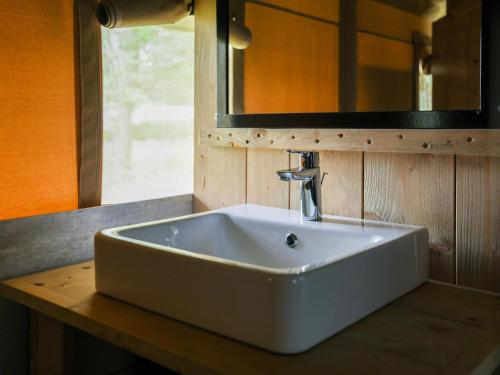 a white sink on a wooden counter in a bathroom at Safaritent 4 in Vessem