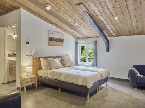 a bedroom with a bed with a wooden ceiling at De Rouwenbogt in Reusel