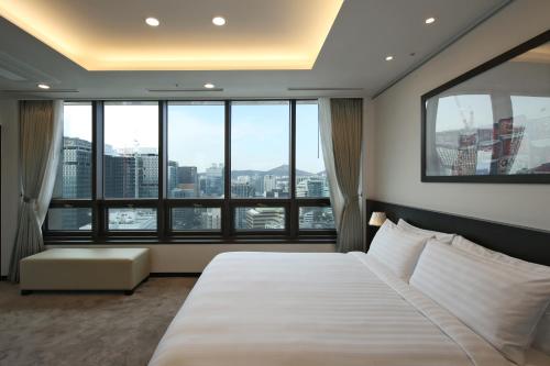 a hotel room with a bed and a large window at Orakai Insadong Suites in Seoul