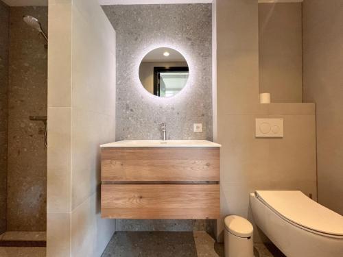 a bathroom with a sink and a toilet and a mirror at Quercus in Valkenswaard
