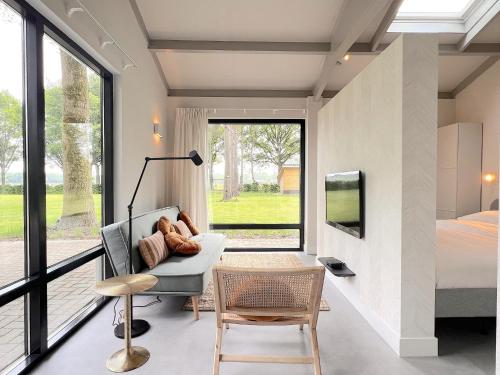 a room with a couch and a bed and a window at Quercus in Valkenswaard