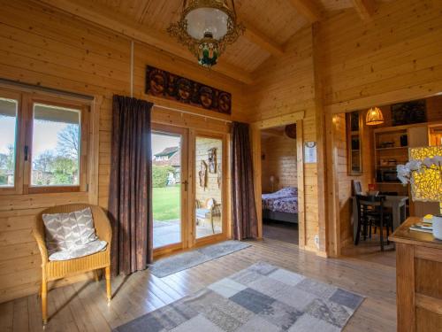 a room with a chair and a window in a cabin at Onder de oude Eik in Lottum