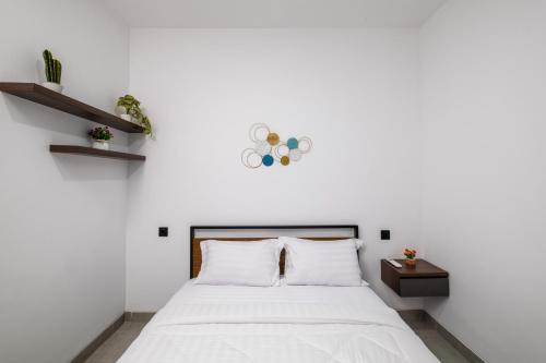 a bedroom with a white bed and a white wall at Gumitish Residence Singaraja in Singaraja
