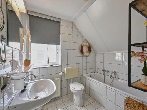 a bathroom with a sink and a toilet and a tub at Rose Garden in Stevensweert