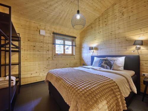a bedroom with a bed in a wooden wall at Bie Leentje op de wei in Schinnen