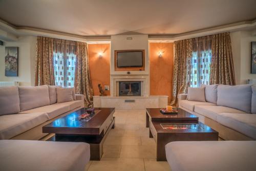 a large living room with couches and a tv at Athena's Holiday Home in Tsilivi