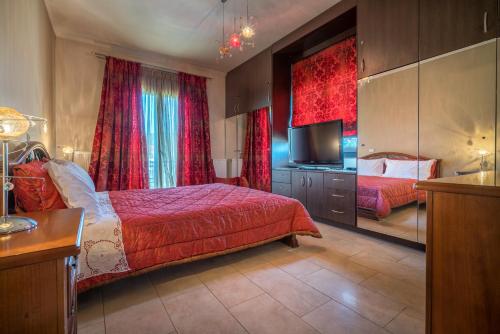 a bedroom with a bed and a flat screen tv at Athena's Holiday Home in Tsilivi