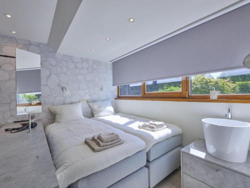 a white bedroom with a large bed and a sink at Silt in Schinnen