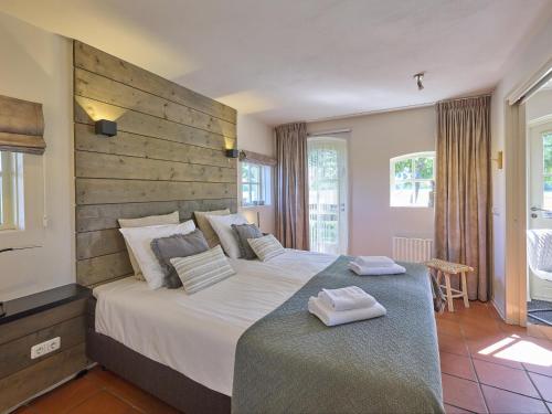 a bedroom with a large bed with a wooden headboard at Pure Rust in Holten