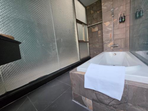a bathroom with a bath tub and a shower at Jason Residencia One Hotel in Phnom Penh