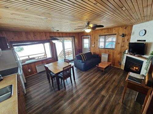 a living room with a couch and a table and a fireplace at Refuge Boréal - Bord du lac paisible in Saint-Ambroise