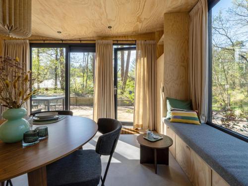 a living room with a table and a large window at Mos in Nunspeet