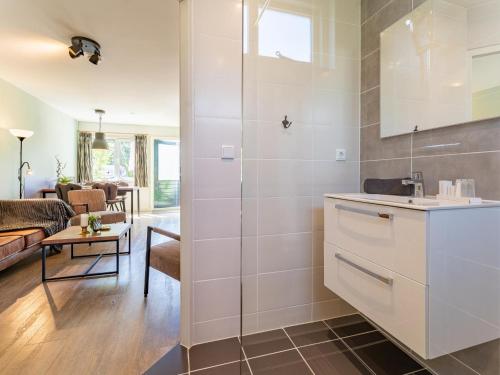 a kitchen with a sink and a living room at Kuifmees in Hulshorst