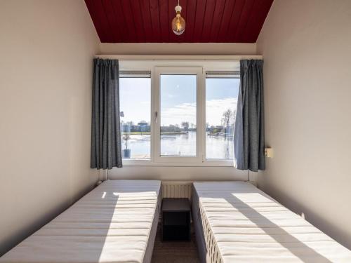 a room with two beds in front of a window at Kieft in Boornzwaag