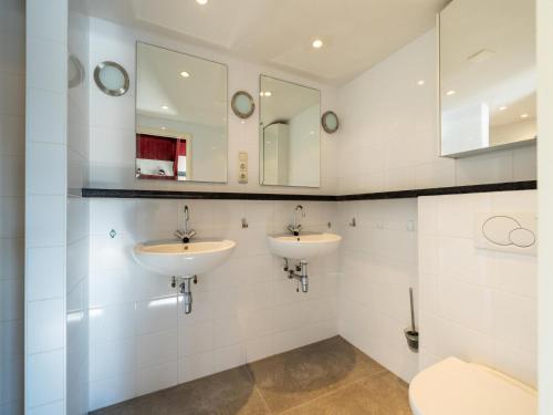 a bathroom with two sinks and a toilet at Kieft in Boornzwaag