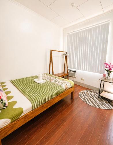a bedroom with a bed and a large window at JRC Feel at Home in Puerto Princesa City