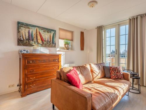 a living room with a couch and a dresser at Schippershuis Stavoren in Stavoren
