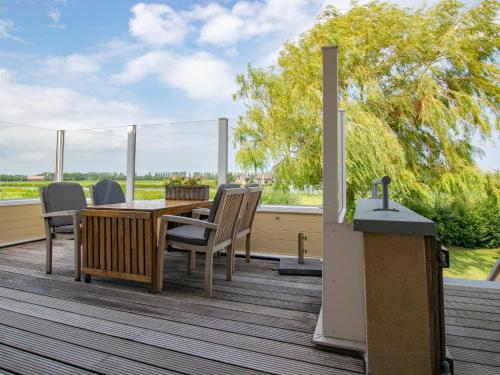 a patio with a table and chairs on a deck at Aquamarijn in Stavoren