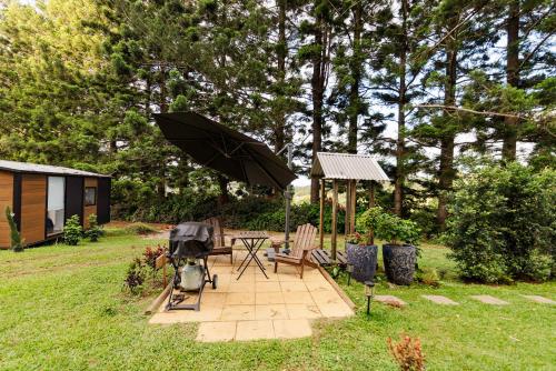 a patio with a grill and a table with an umbrella at Montville Retreat by Tiny Away in Montville