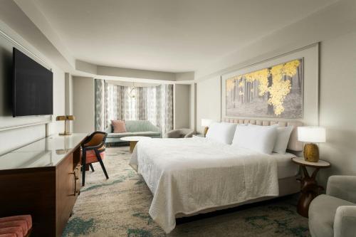 a hotel room with a bed and a living room at Castle Hotel, Autograph Collection in Orlando